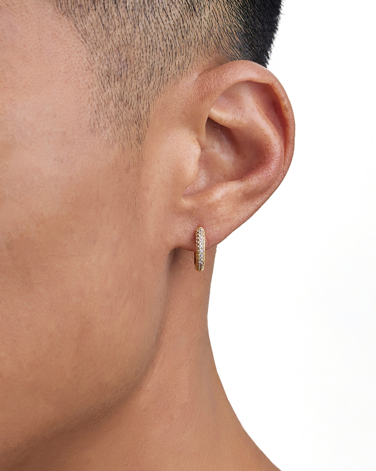 Model wearing 18k gold diamond earrings by Iceman Society